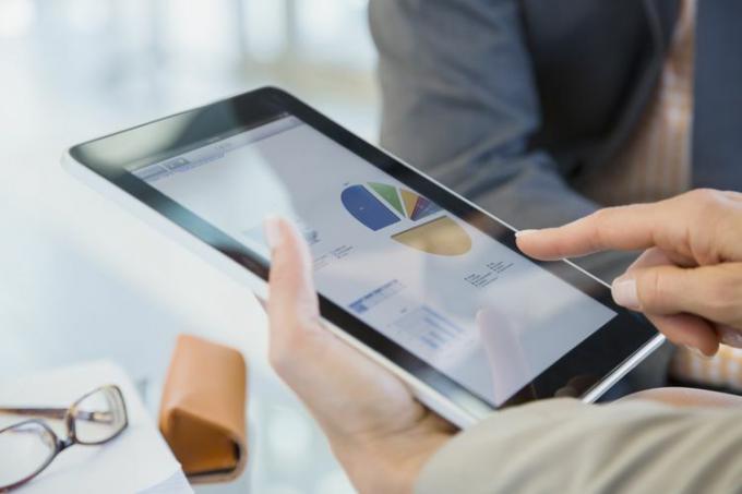 Gente de negocios revisando datos financieros en tableta digital