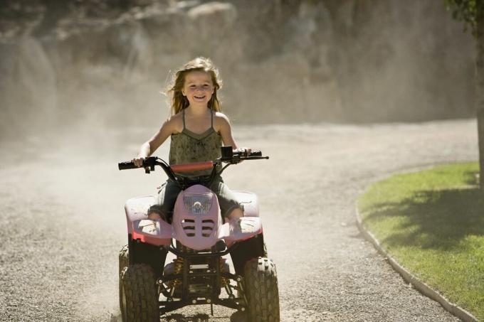 Gadis mengendarai quadbike dan tersenyum