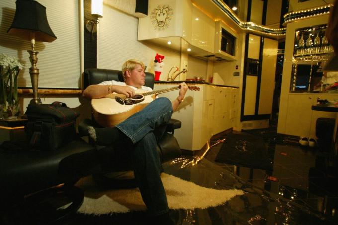 John Daly slappnar av när han spelar sin gitarr i sin husbil inför starten av U.S. Open den 12 juni 2002 i Farmingdale, New York.