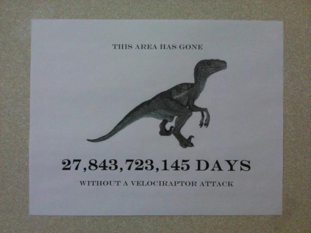 " Bu bölge velociraptor saldırısı olmadan 27.843.723.145 gün geçti" yazan bir tabelanın fotoğrafı.