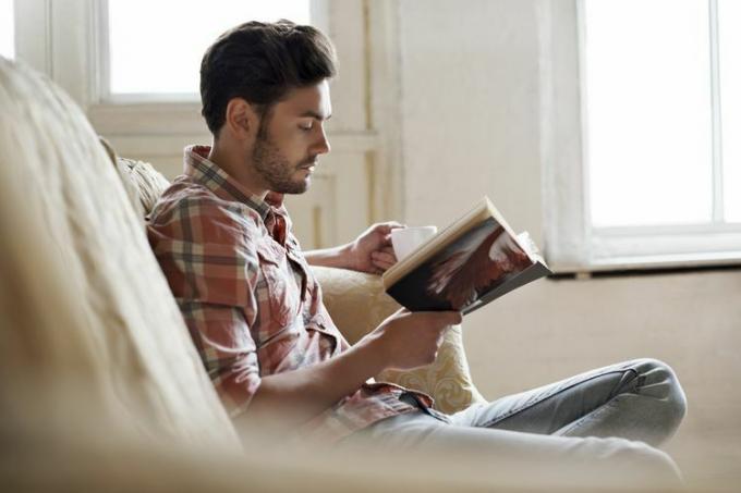 Homme lisant un livre avec du café