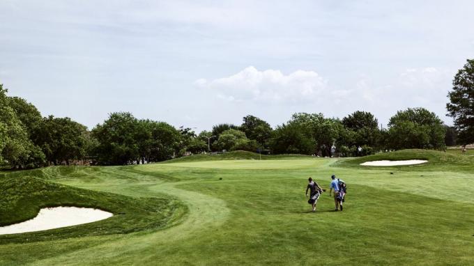 Golfa spēlētāji pietuvojas 14. grīnam Marine Park golfa laukumā.