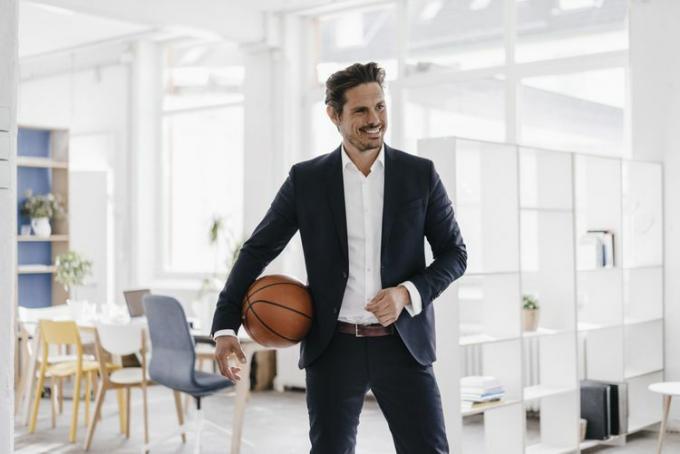 Podnikateľ drží basketbal v kancelárii