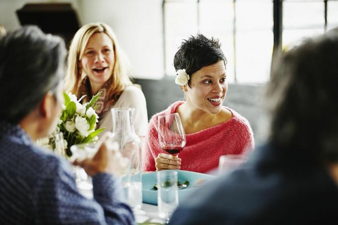 Omã conversando com amigos na mesa durante a festa