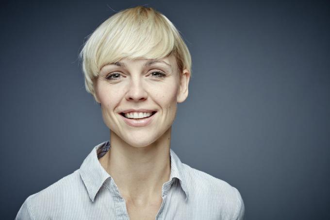 Kvinne med kort hår smiler