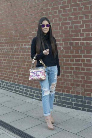 Foto street style di una donna in jeans consumati