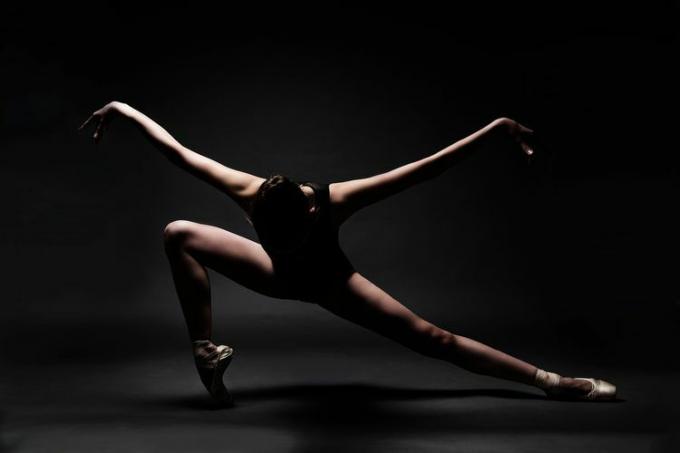 灰色の背景に対して踊るバレエ ダンサー