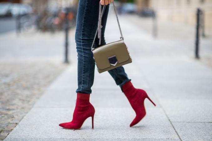 Moteriškos kojos su džinsais ir raudonais auliniais batais