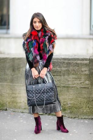 Мода жінка в барвисті штучне хутро пальто і плісе спідниці