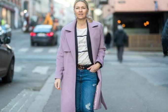 ストリートスタイルの女性のピンクのコートとジーンズ