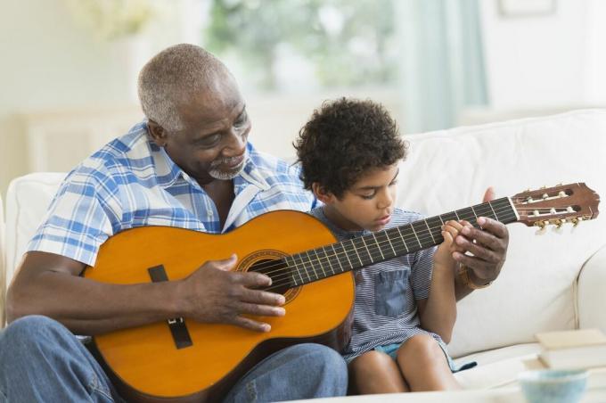 Junge spielt Gitarre mit Großvater