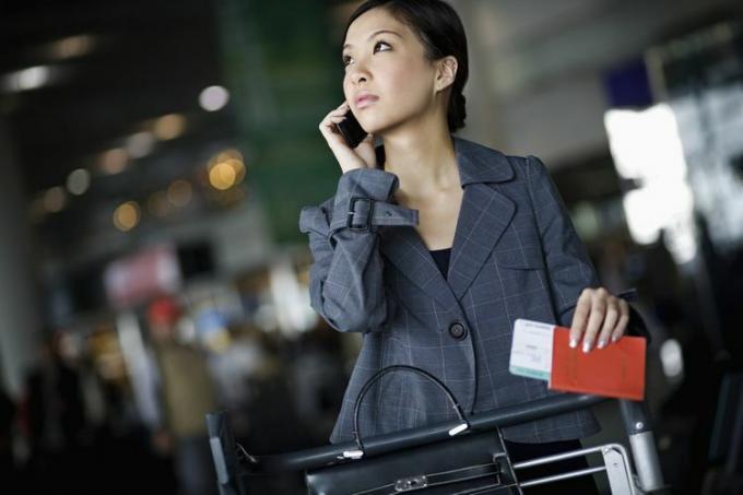 Bizneswoman przy użyciu telefonu komórkowego na lotnisku