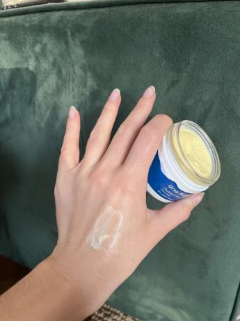 Een hand die Ursa Major-crème vasthoudt